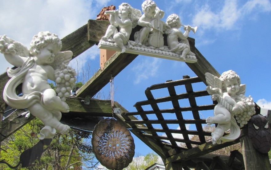 Cherub statues on the deck arch, with a sun rotator in the center and the Spiderman cement face I sculpted on the right.