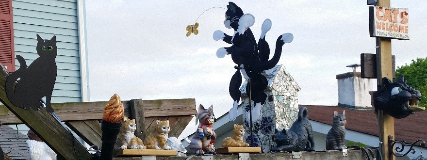 A photo showing the Cat-theme side of my pond pergola, with the air-swing arm in the background, a torch light I made in the foreground, and the cat lightpole on the right.