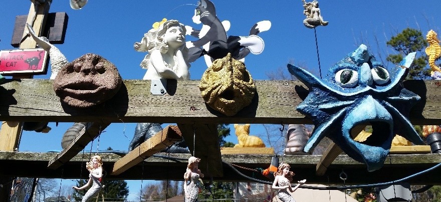 The pergola over the fish pond featuring mermaids and cement faces.